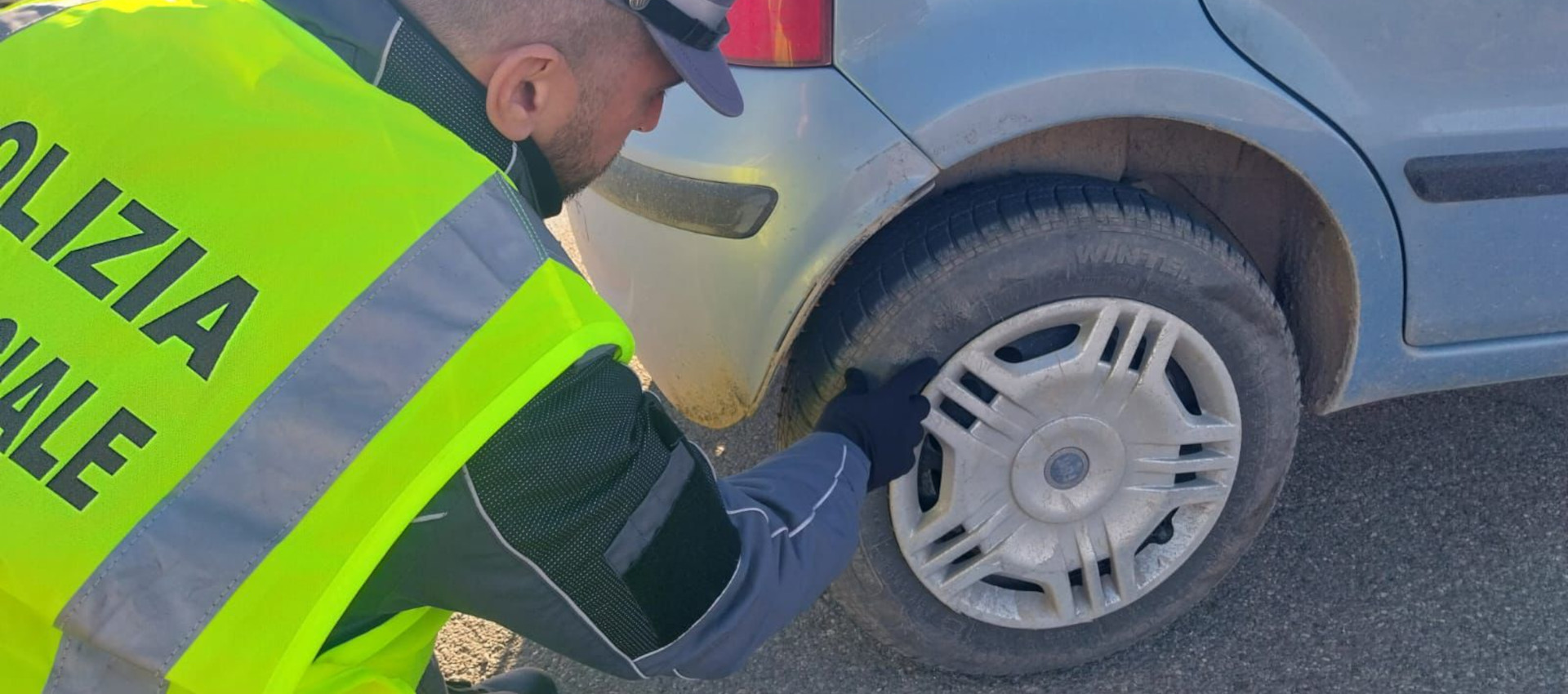 Dettaglio di un agente impegnato in un controllo gomme