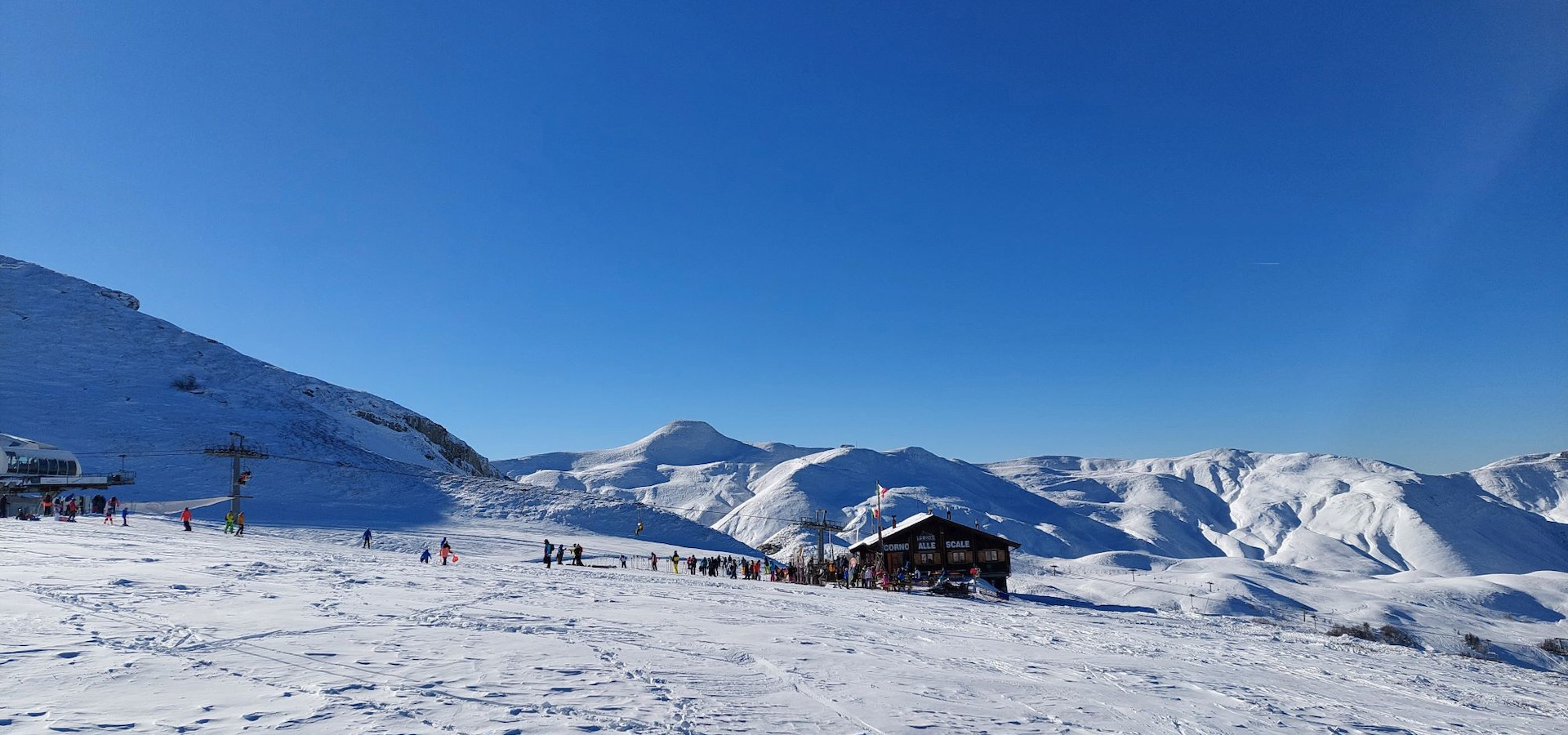 Panorama del Corno alle Scale innevato con sciatori